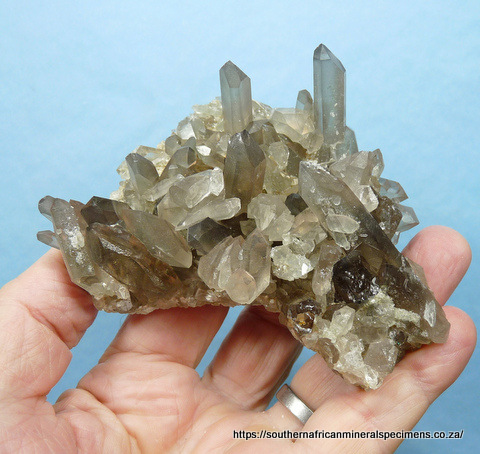 Quartz crystal group with hematite 'capping' and minute clusters